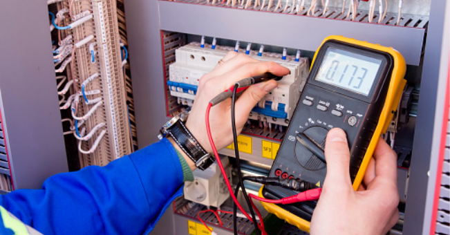 A man using a multimeter to check an electrical panel.
