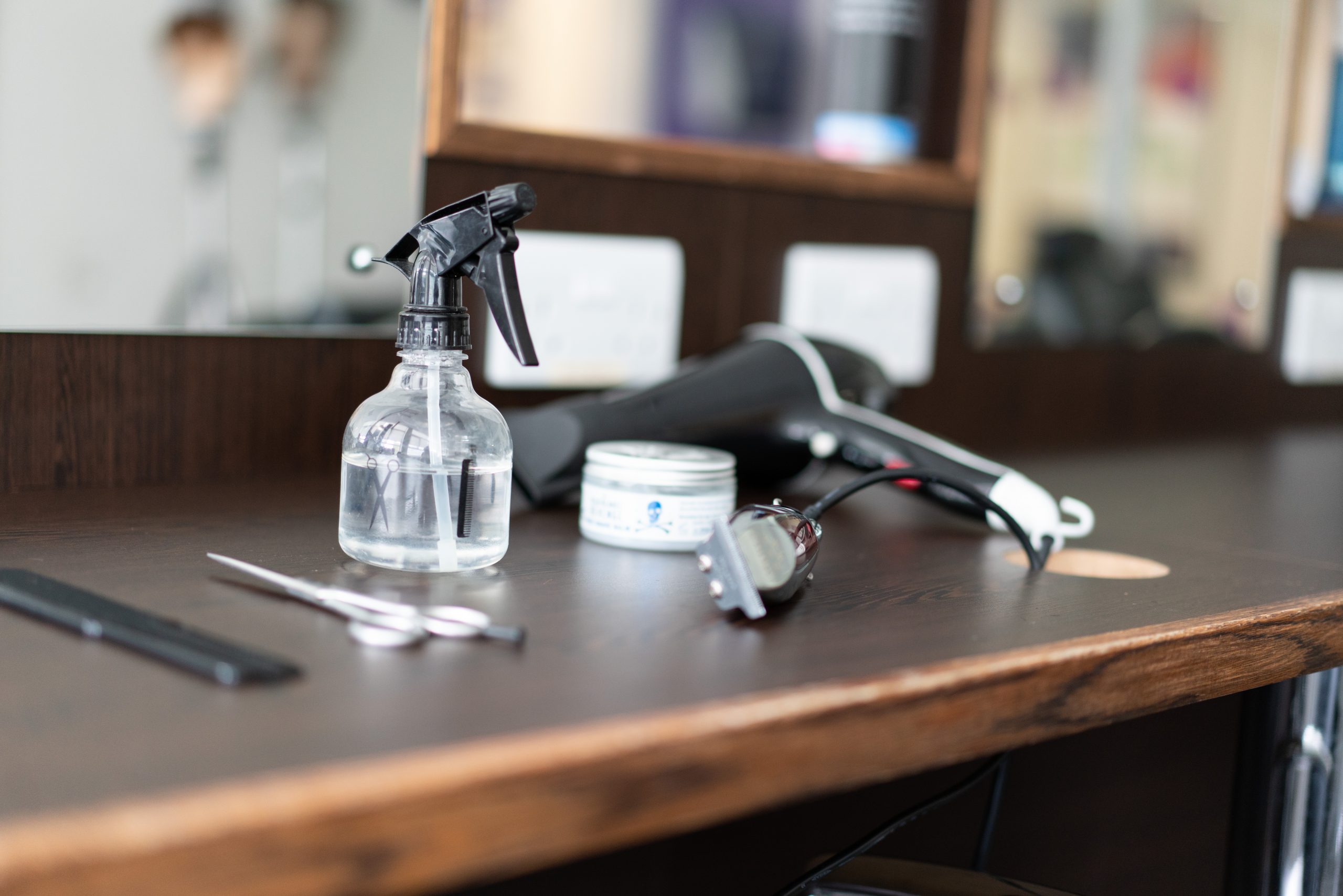 A bench in a barbershop with a barbers tools laid out.