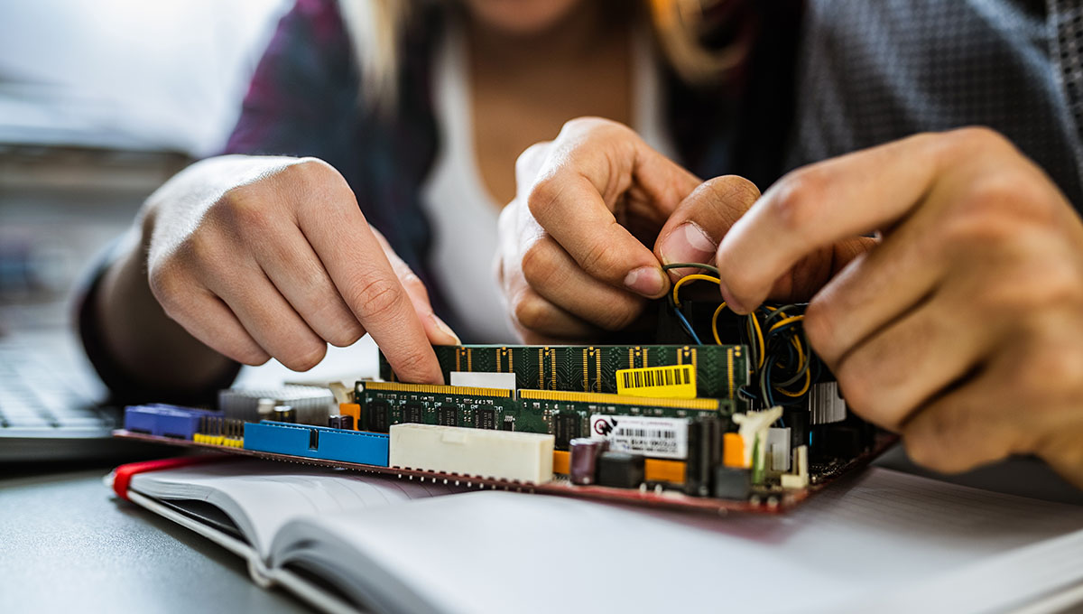 Close up of unrecognizable engineers repairing mother board.