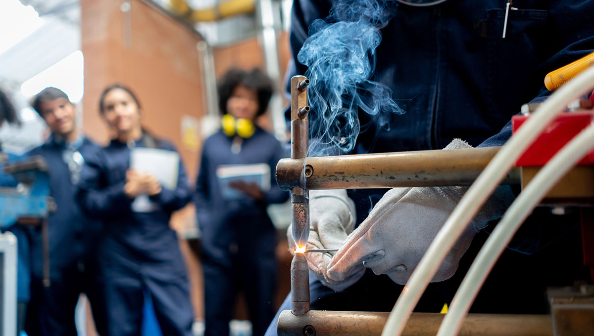 Group of students learning how to weld