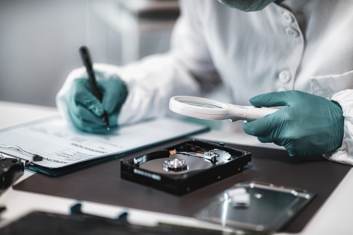 Police Forensic Analyst Examining Computer Hard Drive.