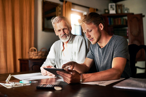 Shot of two men working on a project together at home